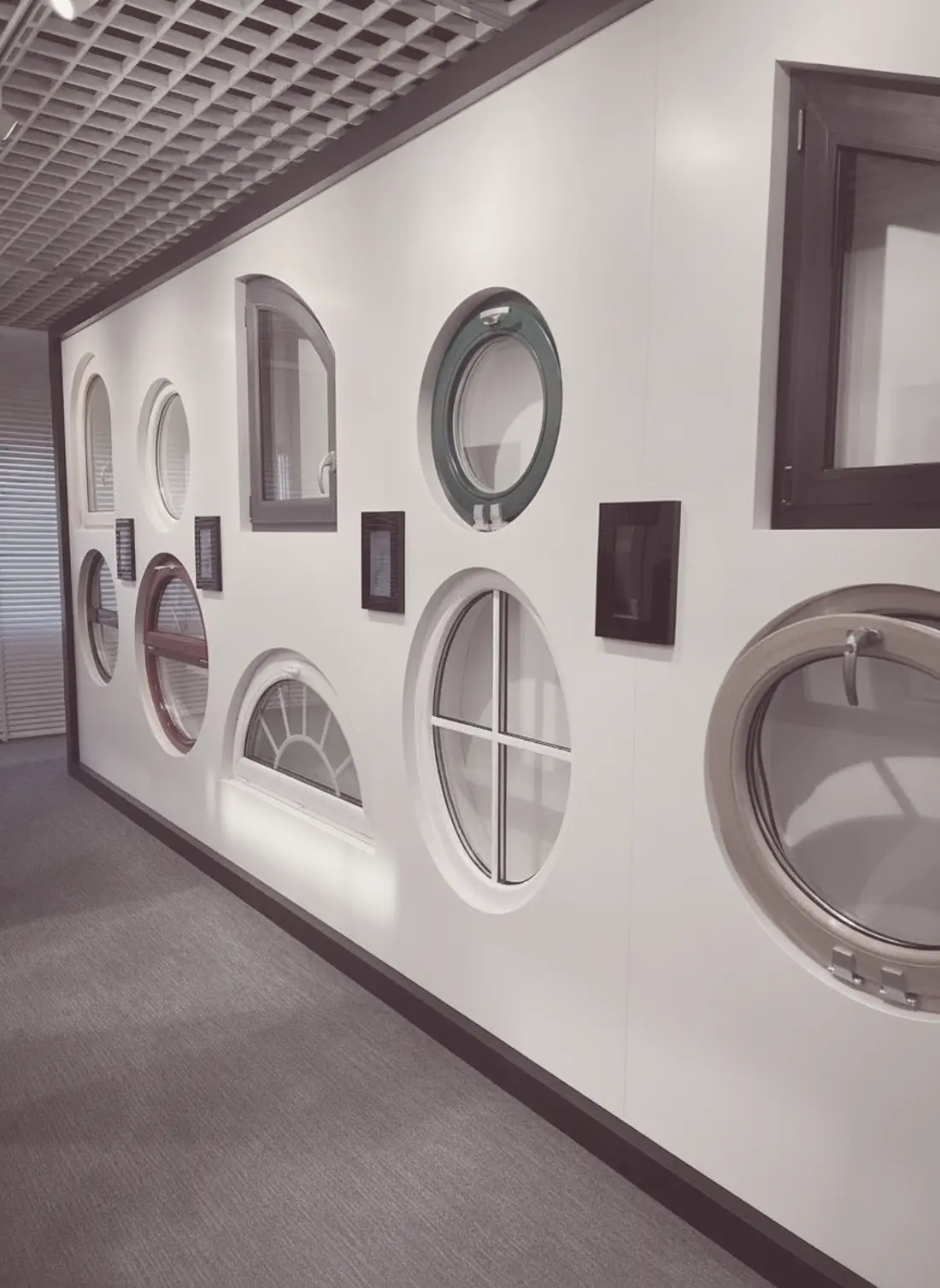 Wand mit runden, ovalen und bogenförmigen Fenstermustern im Showroom